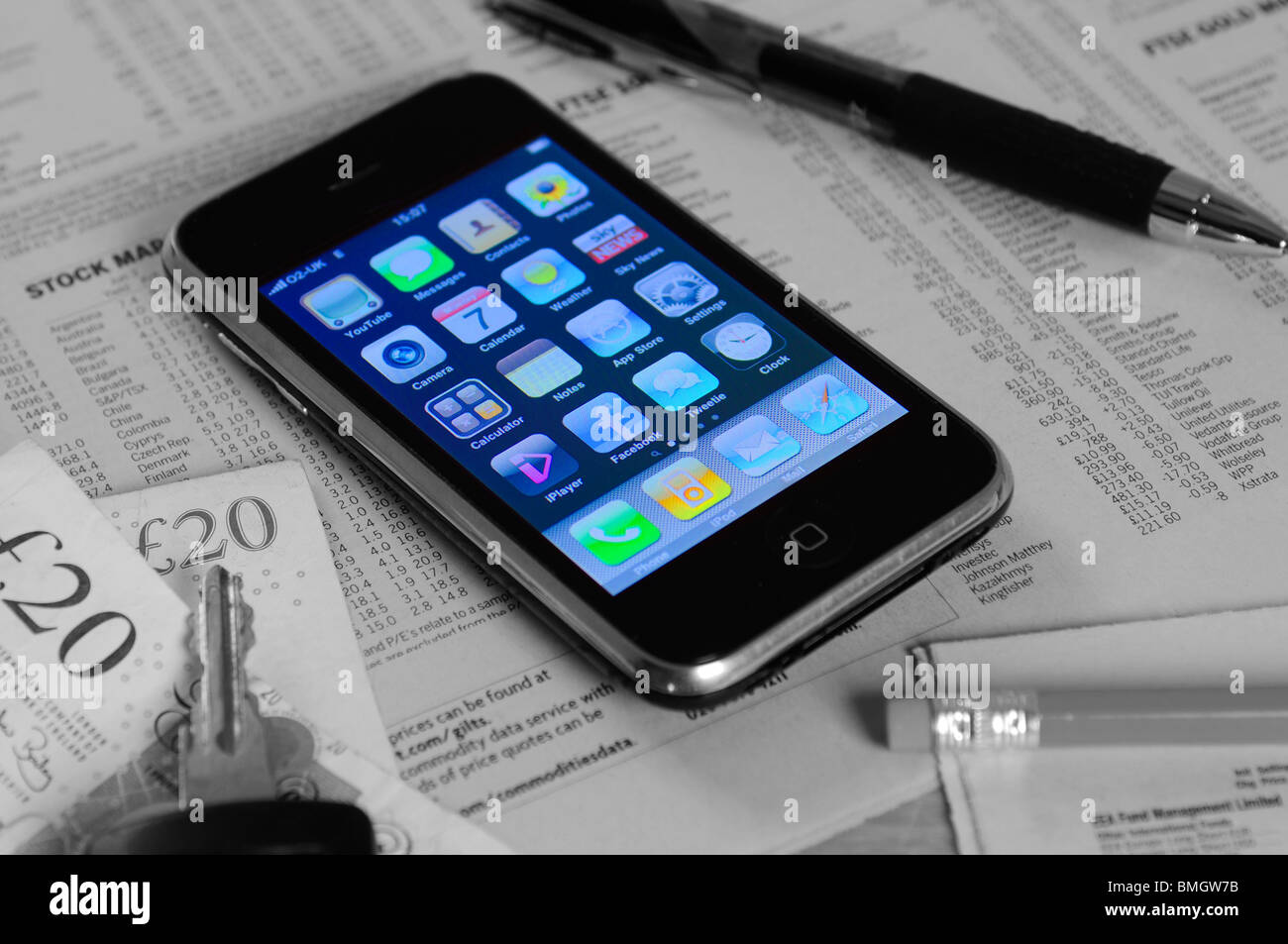an iphone with a newspaper displaying stocks and share prices Stock Photo