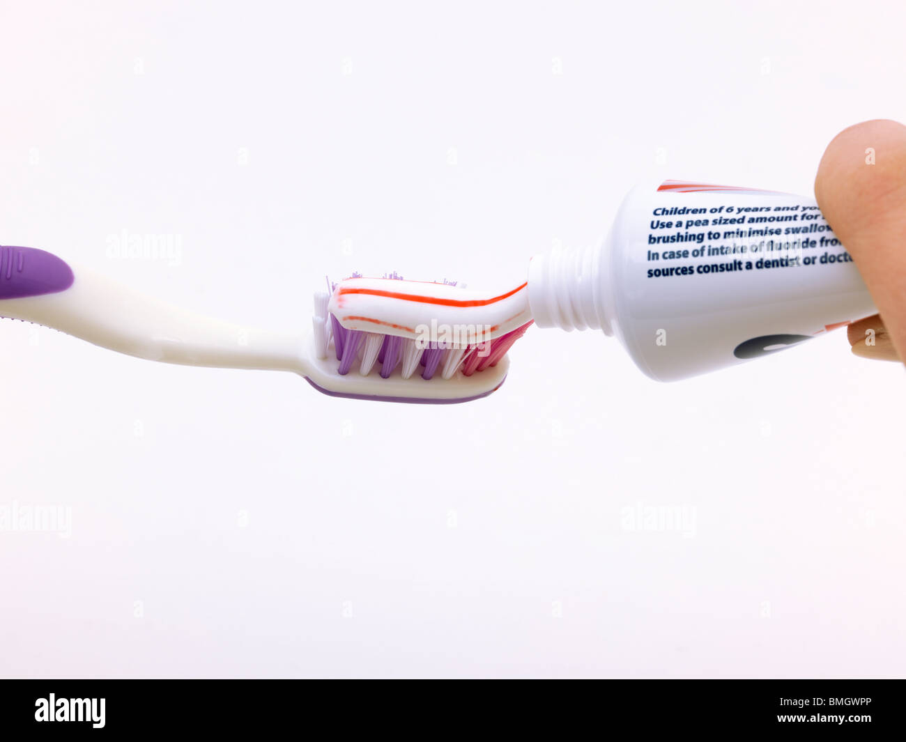 Squeezing Toothpaste From Tube On To Purple Toothbrush Stock Photo Alamy