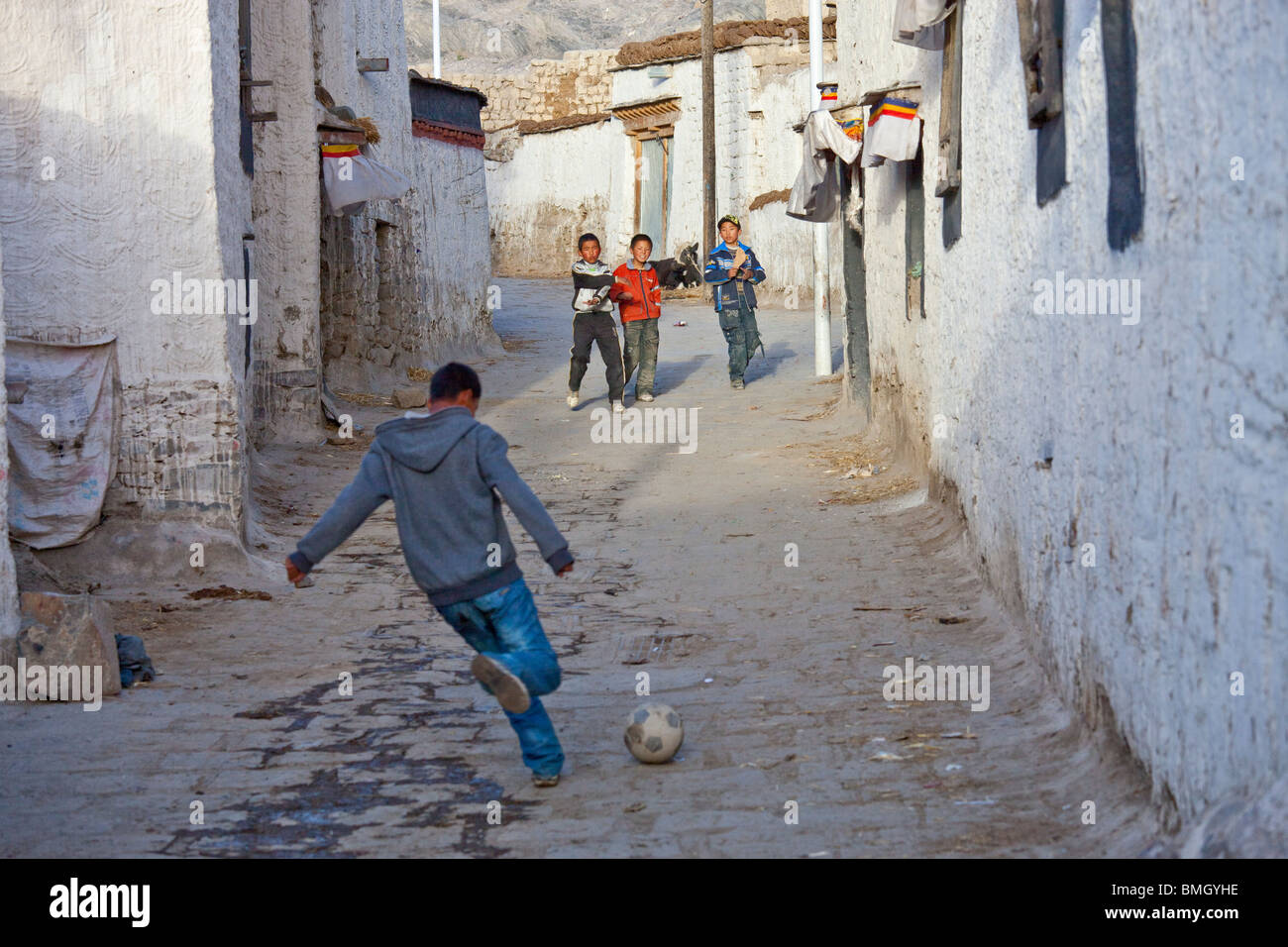 Boys kicking a football in Gyantse, Tibet Stock Photo