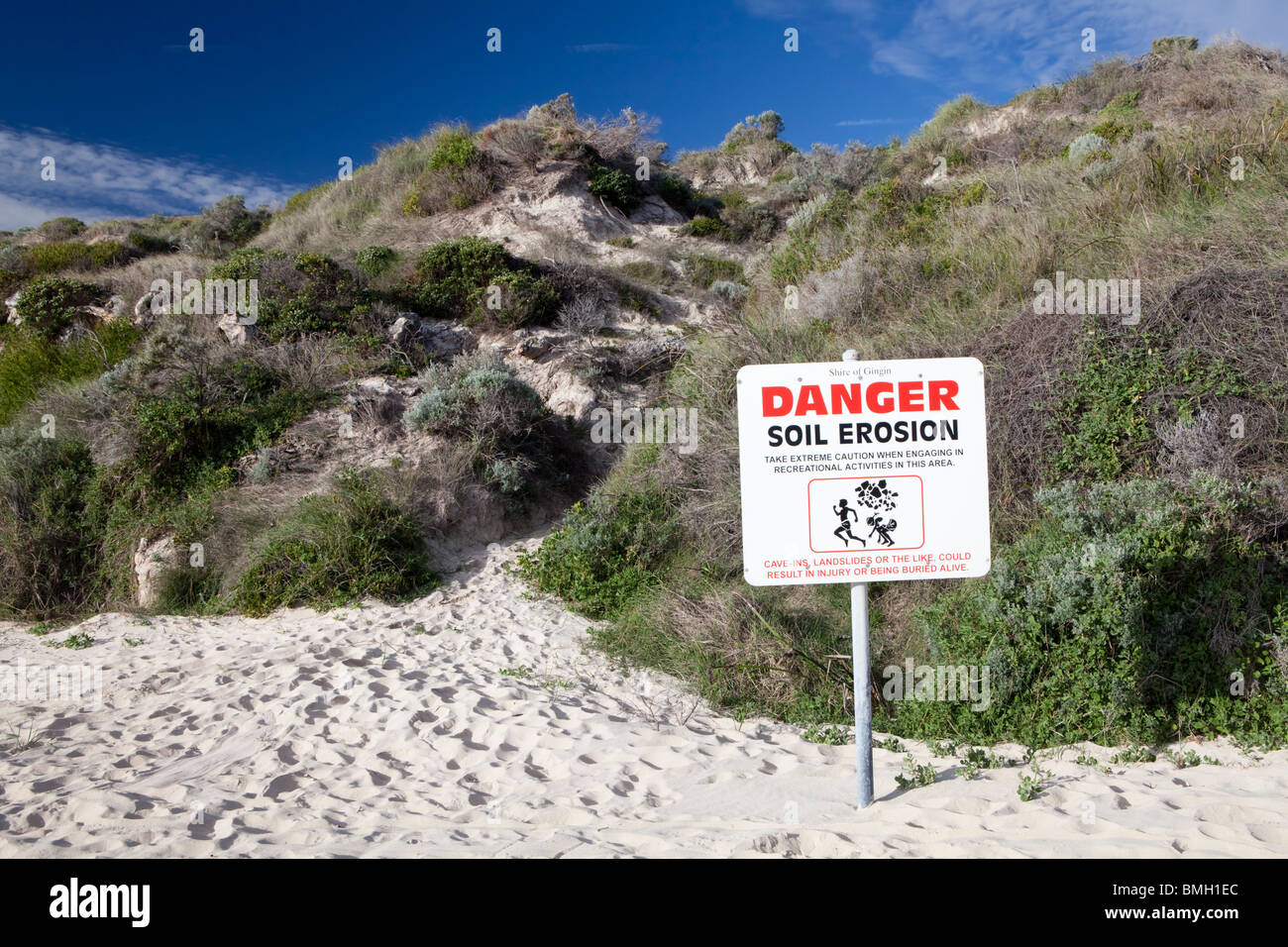 'Danger Soil Erosion' sign next to a beach and hill at Guilderton, Western Australia Stock Photo