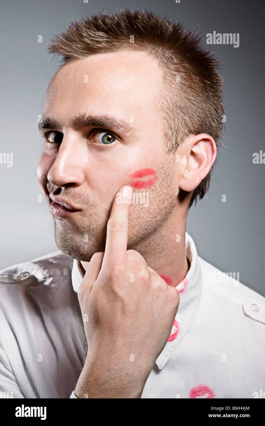 young man pointing on cheek with kiss imprint Stock Photo
