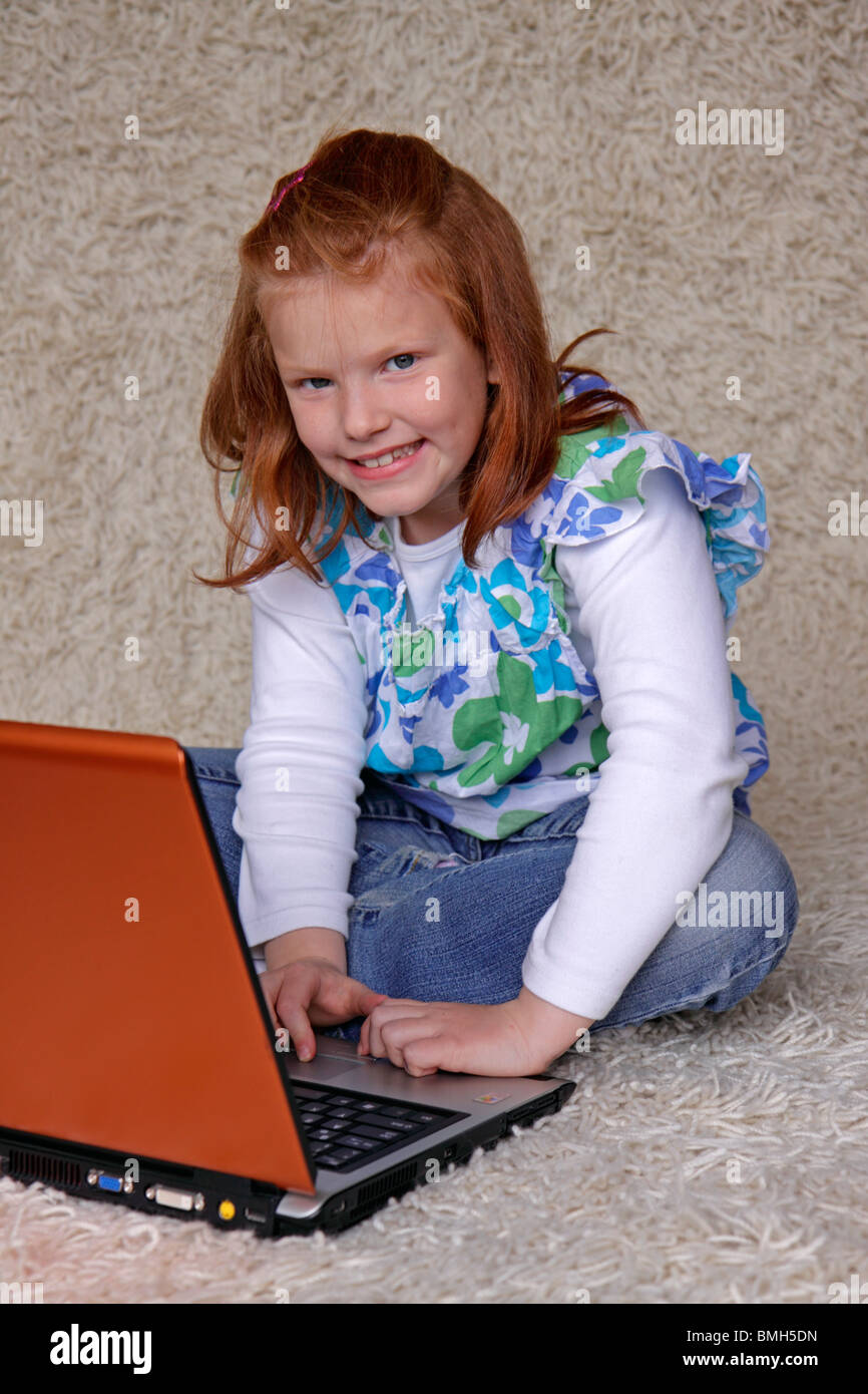 portrait of a young girl sitting on the floor with her laptop Stock ...