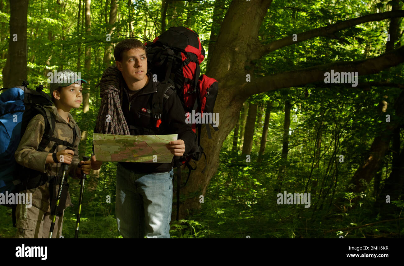 Father and son hiking in forest. Looking at map Stock Photo - Alamy