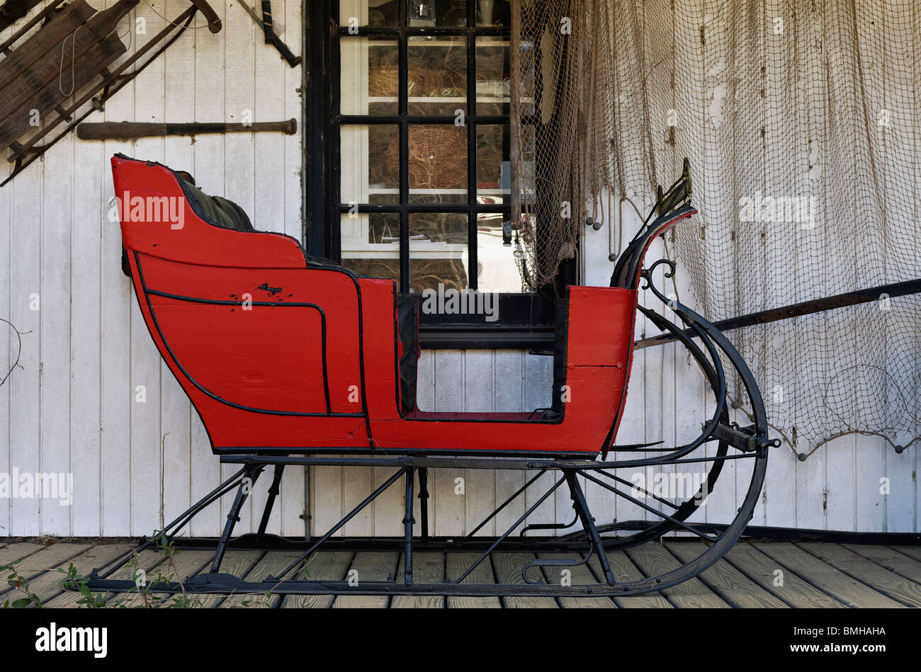 Red Sleigh on the Front Porch at the Thieves Market Antique Store in Mount Pleasant, South Carolina Stock Photo