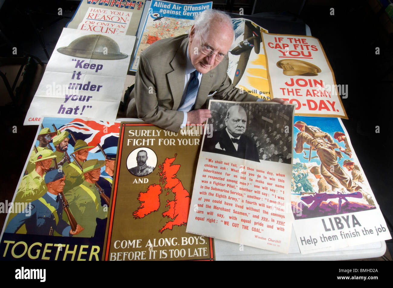 Roy Butler an expert on Militaria for the BBC's 'Antiques Road Show' inspects World War 1 and World War 2 posters. Stock Photo
