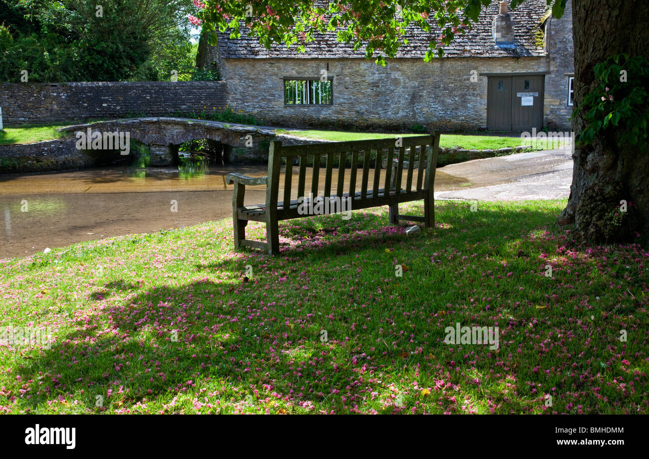 Wooden bench overlooking the ford in the pretty Cotswold village of Shilton, Oxfordshire, England, UK Stock Photo