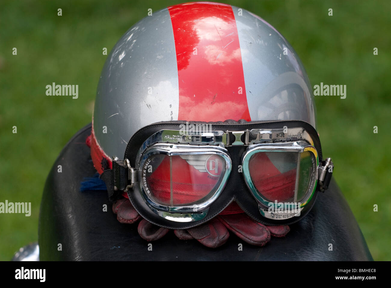 An old classic motorbike helmet perched on the seat of a bike Stock Photo