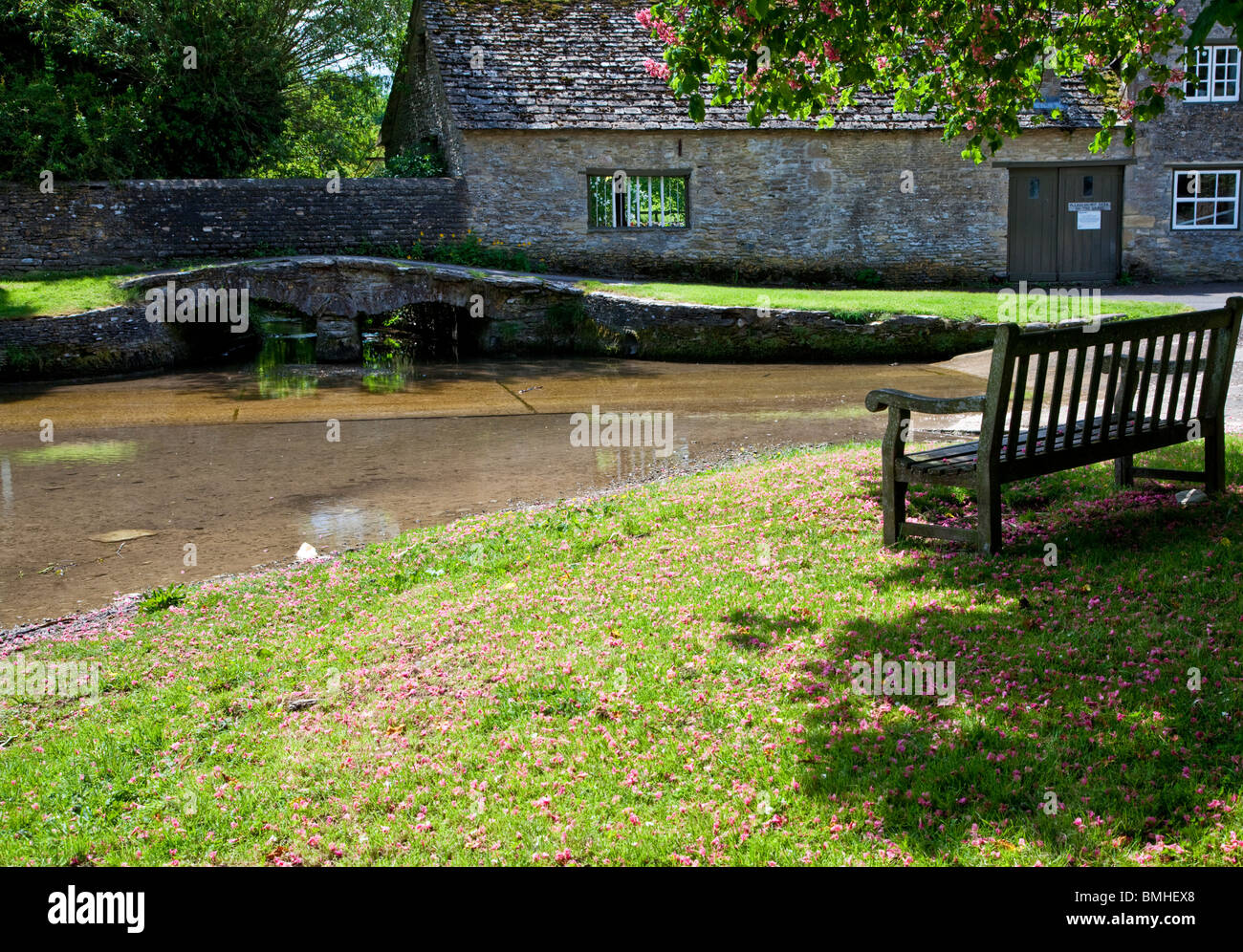 Wooden bench overlooking the ford in the pretty Cotswold village of Shilton, Oxfordshire, England, UK Stock Photo