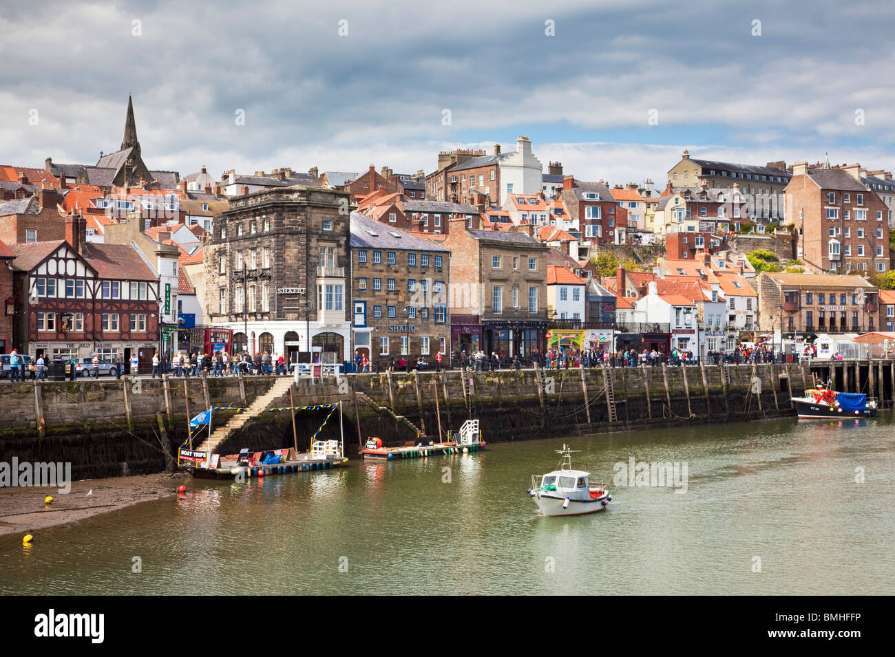 Tourists on Whitby Harbour overlooking the River Esk, Whitby, North Yorkshire, England, UK Stock Photo