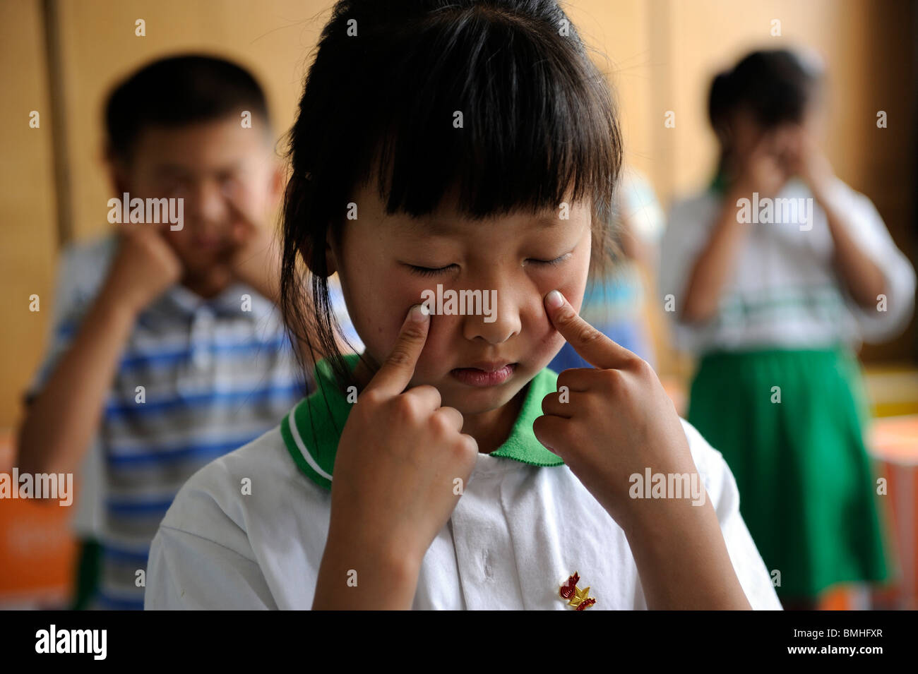 Chinese students practice eye exercises during a lesson at a primary school in Pinggu, Beijing, China. 07-Jun-2010 Stock Photo