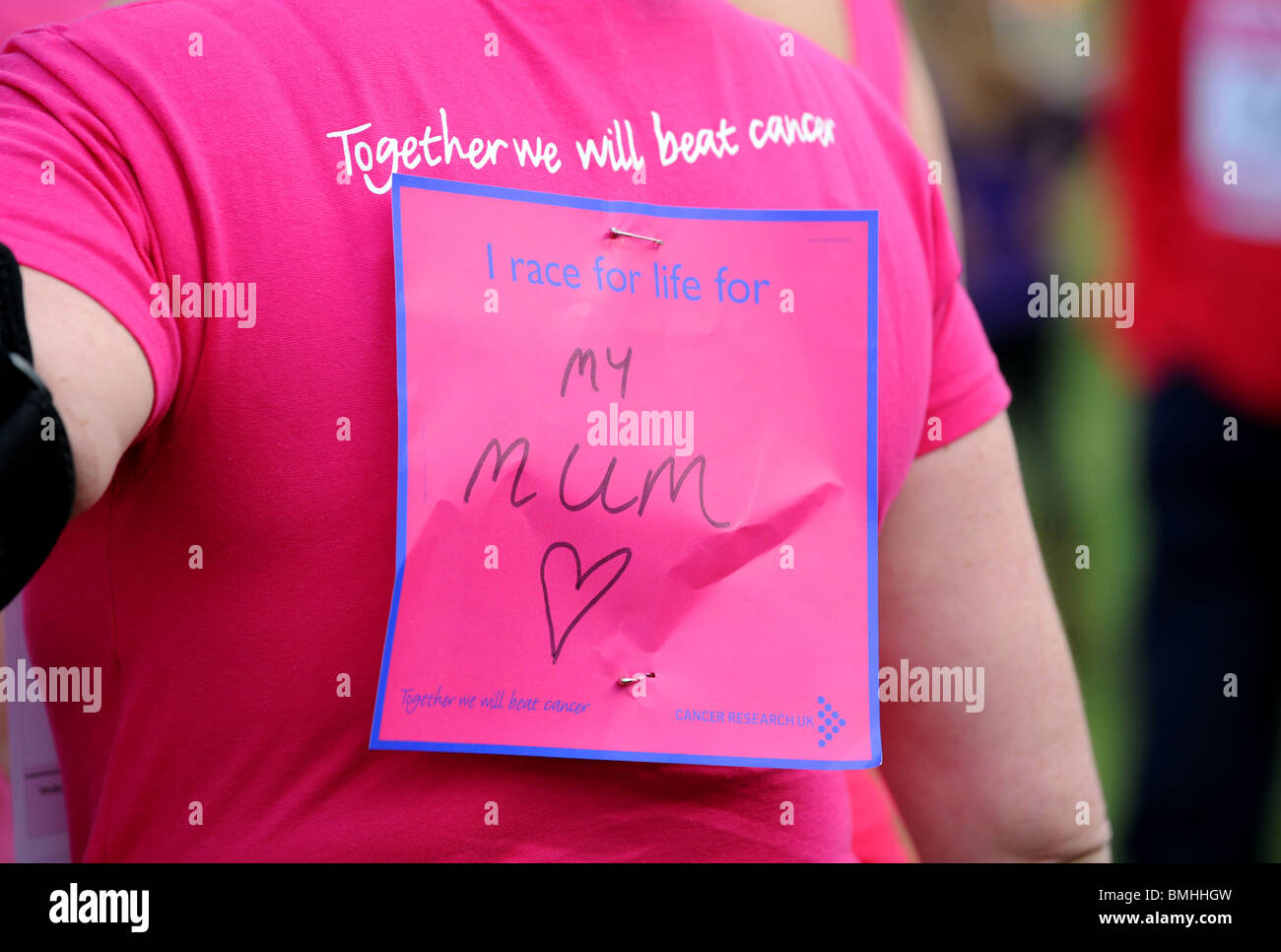Messages on the backs of women taking part in the Cancer Research Race for Life event at Crawley Stock Photo