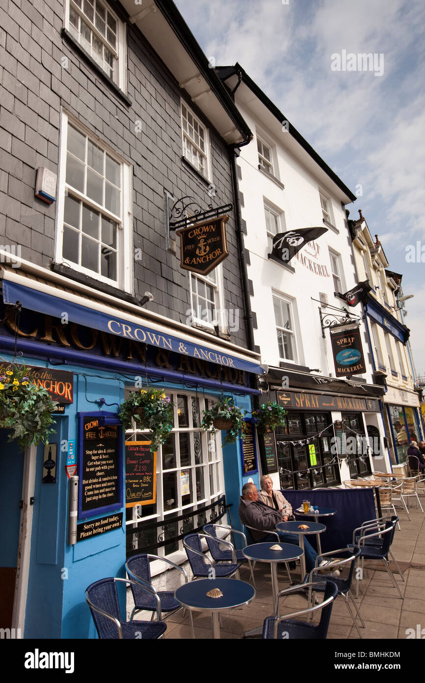 UK, England, Devon, Brixham Harbour, customers at pavement tables outside quayside pub restaurants Stock Photo