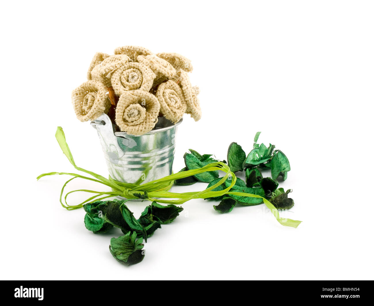 Handmade flowers in small bucket and green potpourri on white