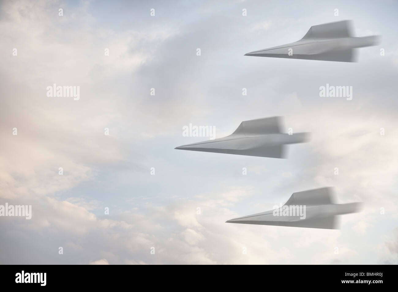 Three paper airplanes flying through the air Stock Photo