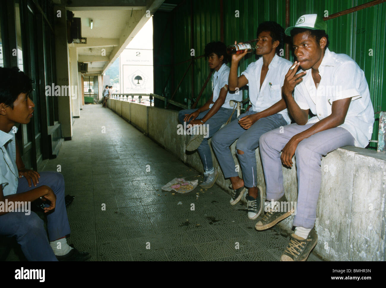 Papuan and indonesian youths smoking and drinking in the capital of West Papua, Jayapura. Stock Photo