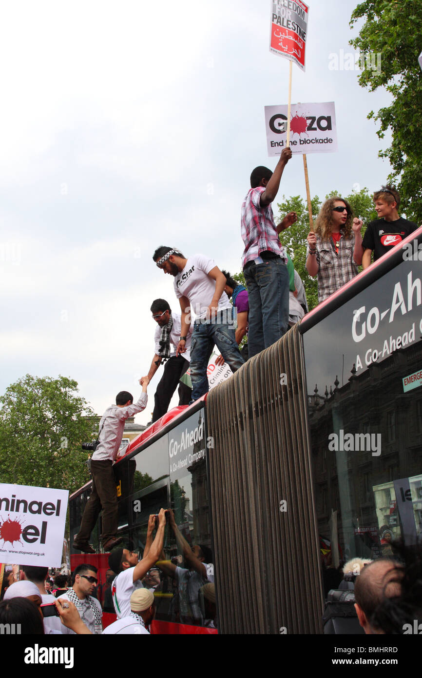 Demonstrators on a bus roof at the 'Freedom for Palestine' demonstration on Whitehall, Westminster, London, England, U.K. Stock Photo