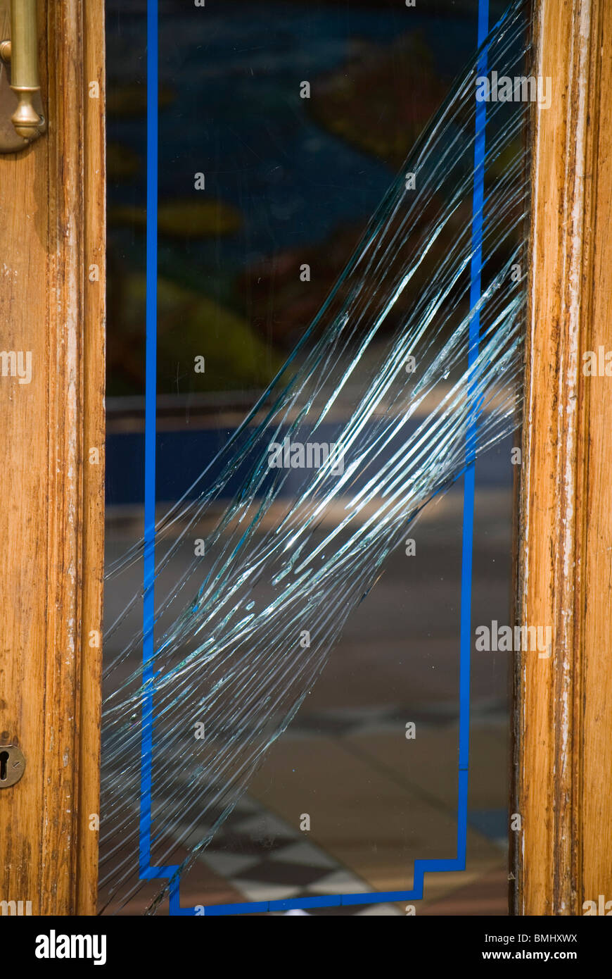 Broken glass panel in the door of a chipshop in the centre of Edinburgh, Scotland. Stock Photo