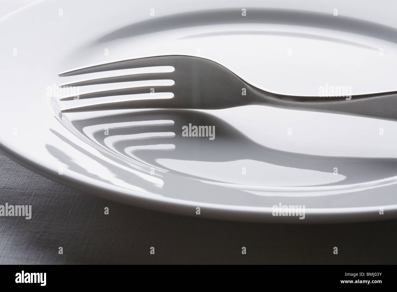 Fork on empty white plate Stock Photo