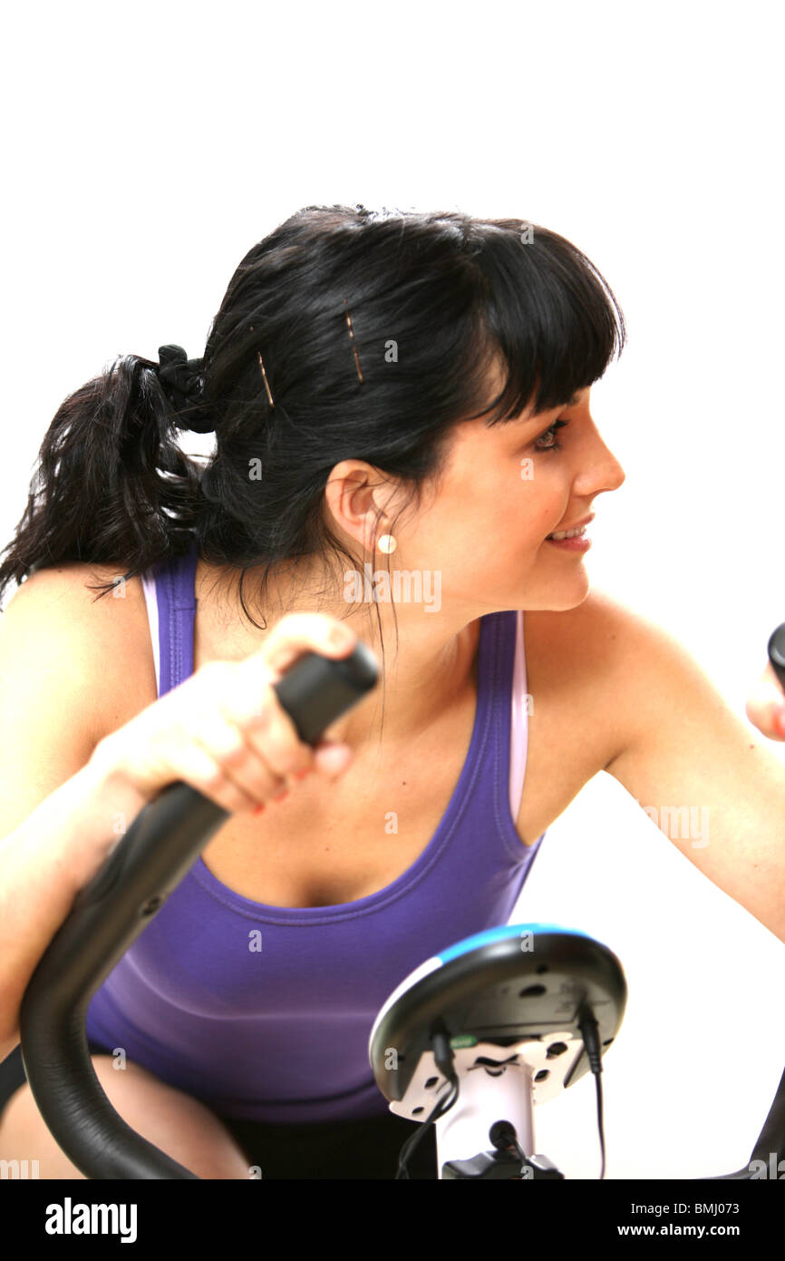 Young Woman Riding Exercise Bike. Model Released Stock Photo