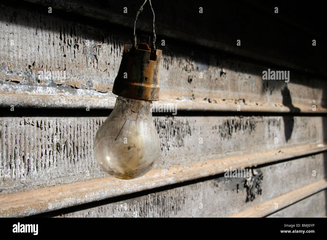 one old damaged light bulb outdoors by shop shutters Stock Photo Alamy