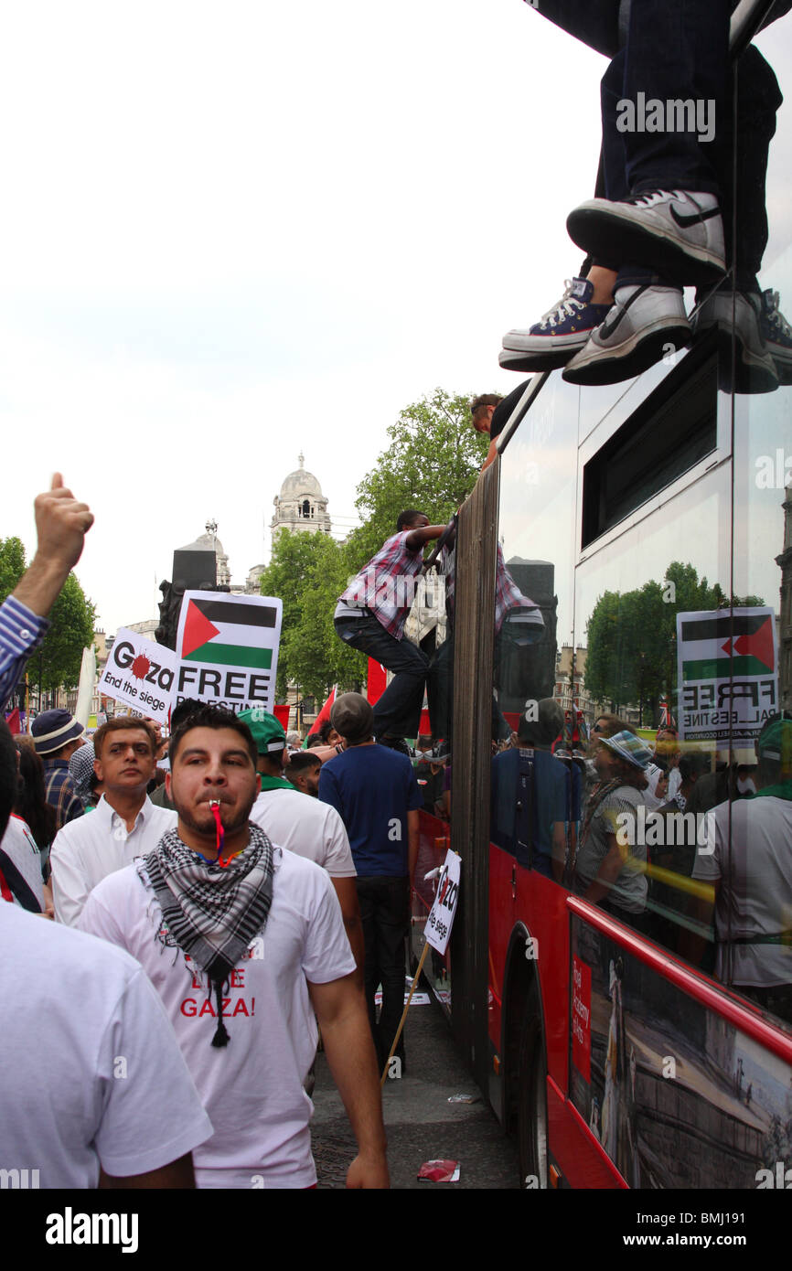 Demonstrators on a bus roof at the 'Freedom for Palestine' demonstration on Whitehall, Westminster, London, England, U.K. Stock Photo