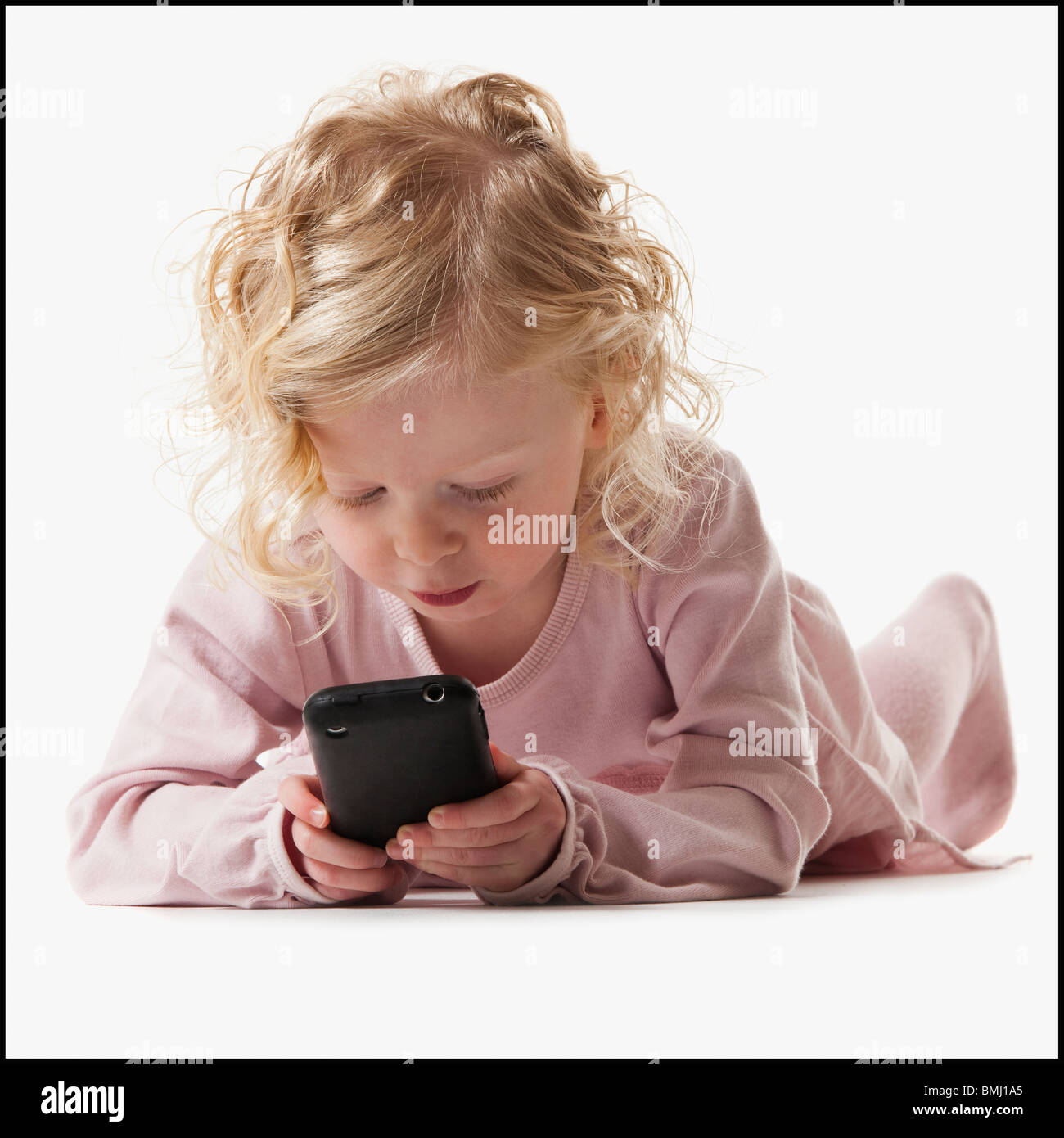 Young girl playing with a cellular phone Stock Photo