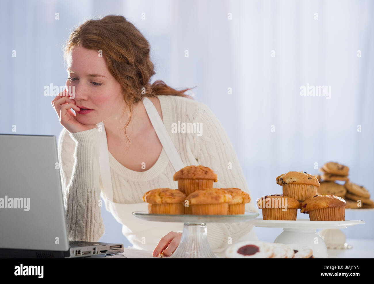 Woman baking and reading recipe Stock Photo Alamy