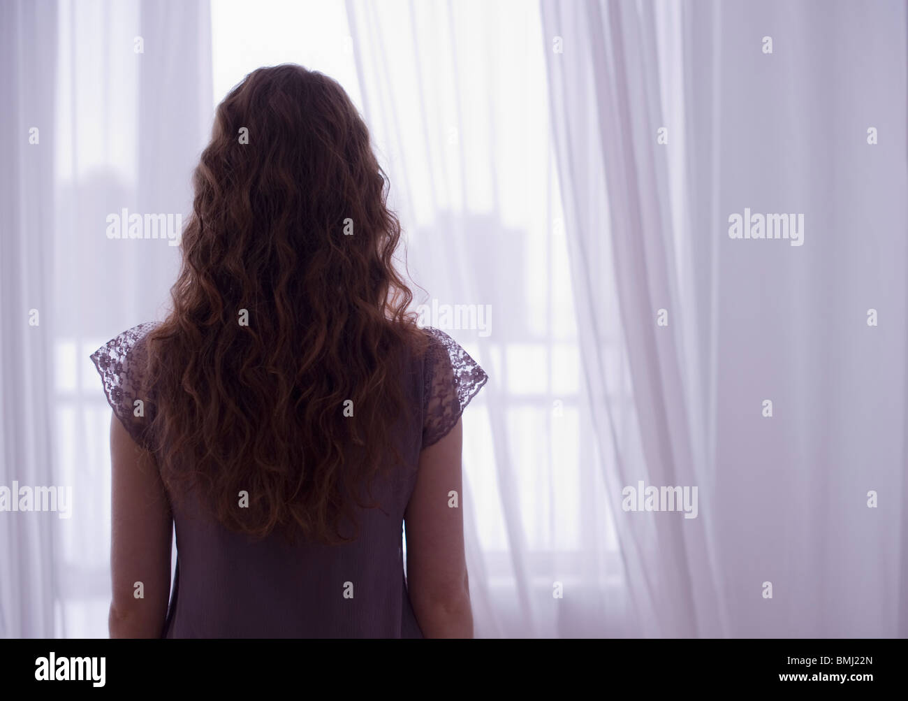 Woman looking out window Stock Photo