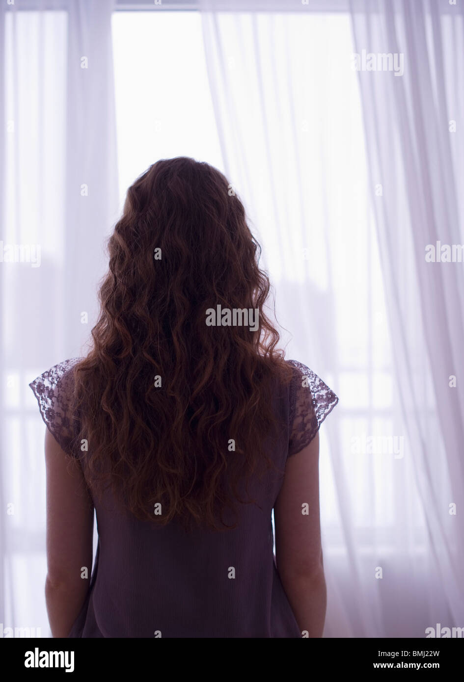 Woman looking out window Stock Photo