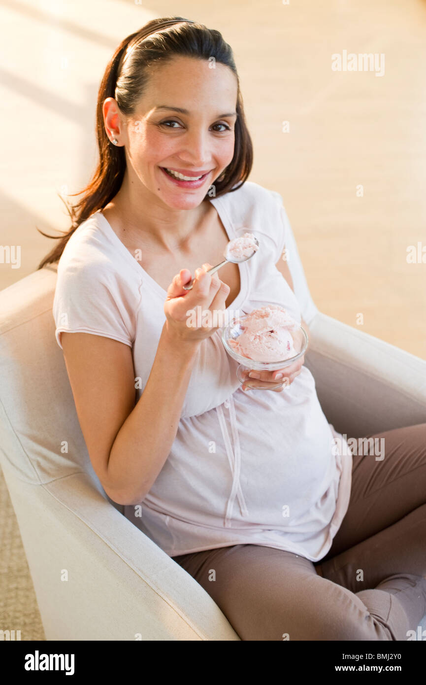 Pregnant woman eating a bowl of ice cream Stock Photo