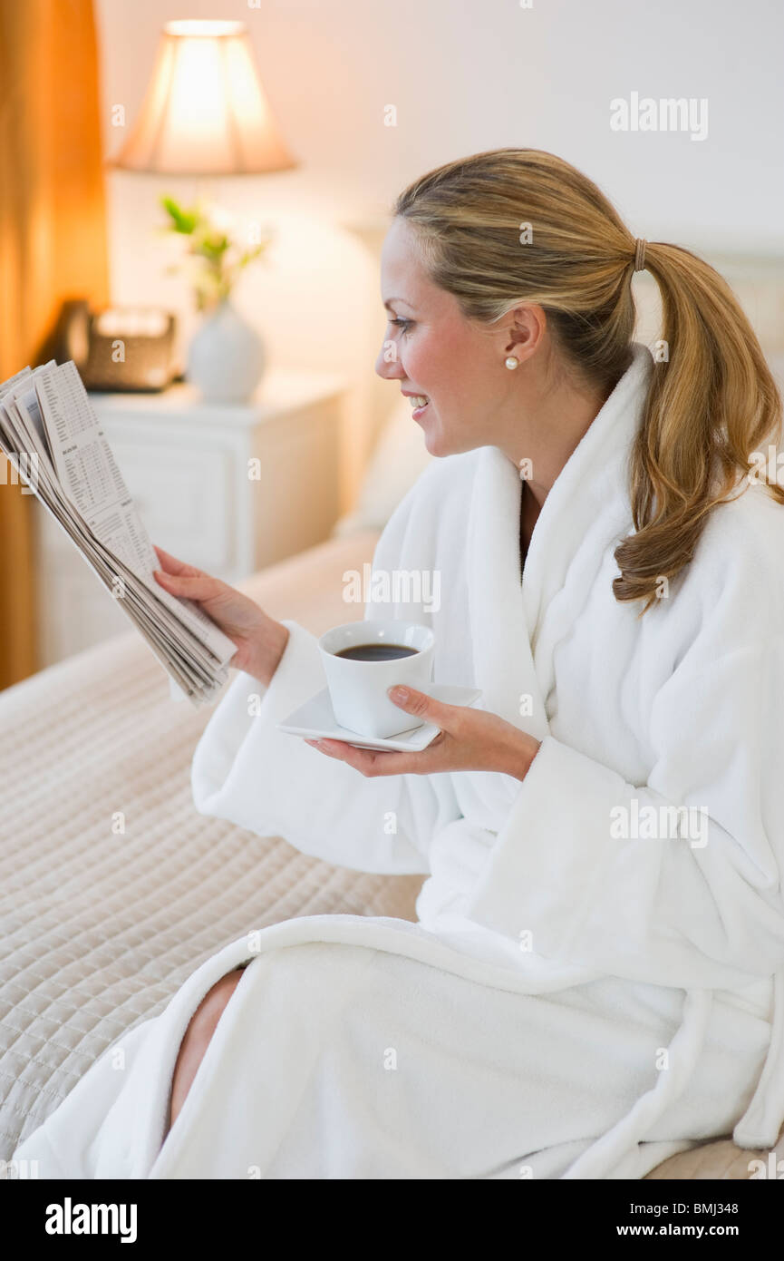 Woman drinking coffee in hotel room Stock Photo