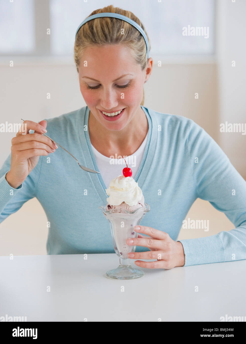 Woman eating ice cream sundae Stock Photo
