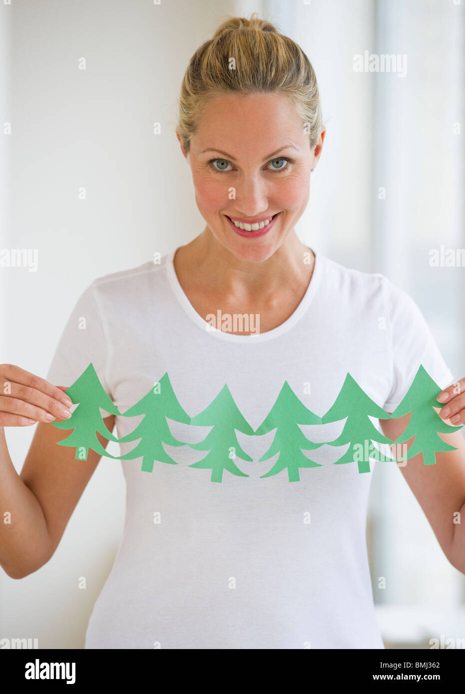 Woman holding cut out of trees Stock Photo