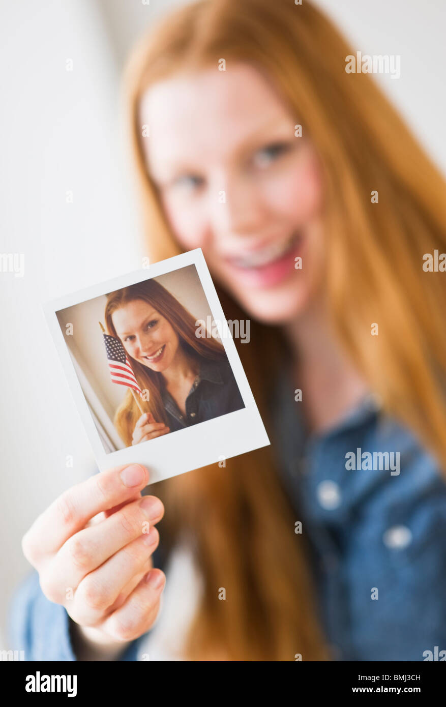 Woman holding photograph of herself Stock Photo