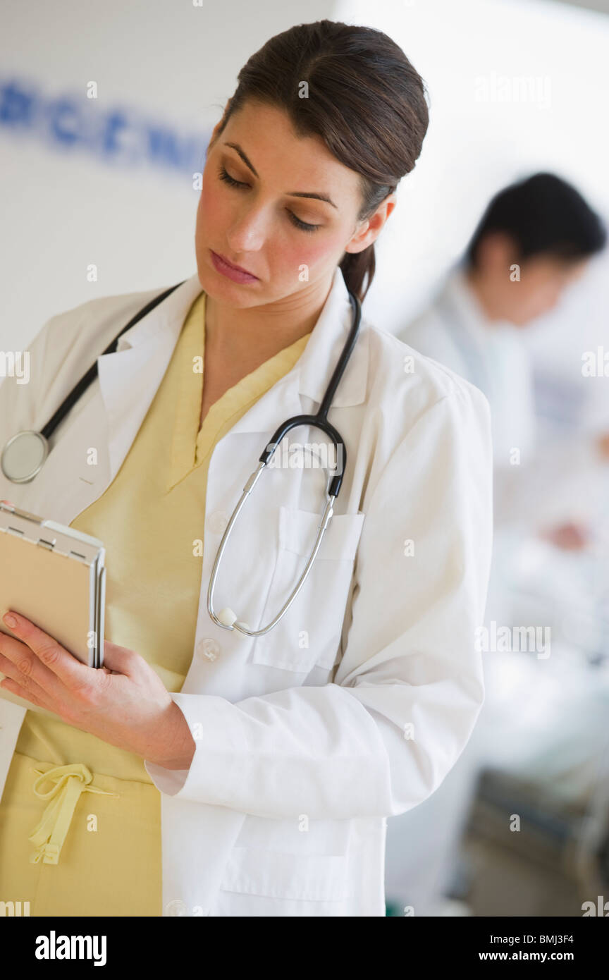 Doctor writing on chart Stock Photo