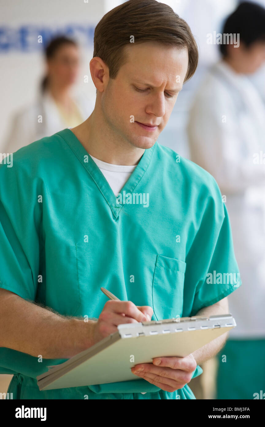 Doctor writing on chart Stock Photo