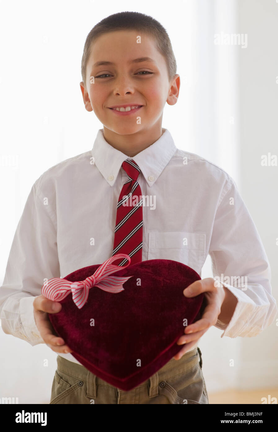Young boy holding a box of chocolates Stock Photo
