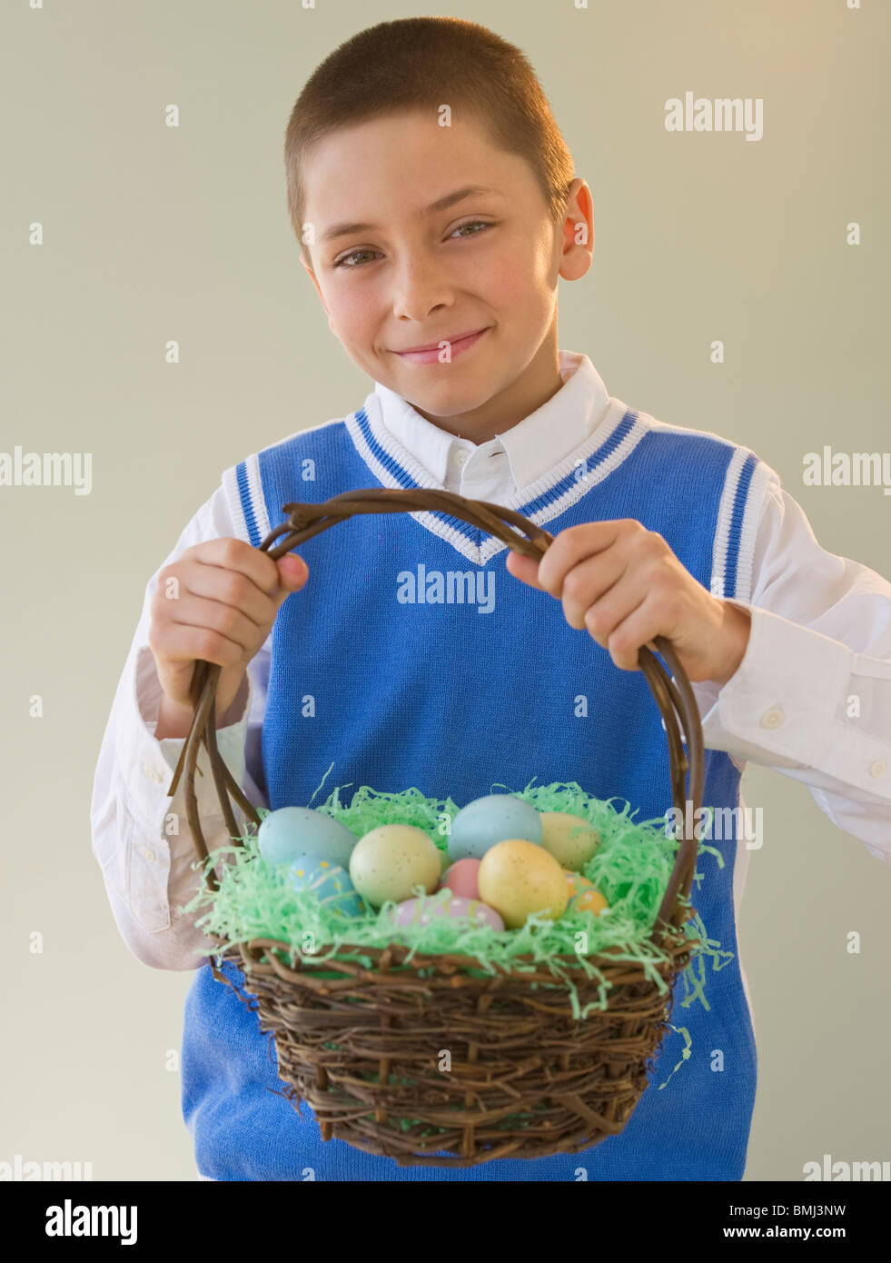 Young boy holding a basket of Easter eggs Stock Photo