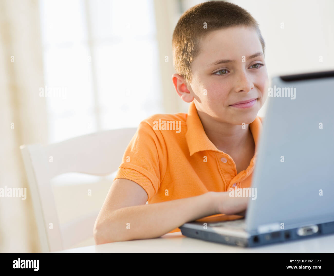 Young boy working on laptop Stock Photo