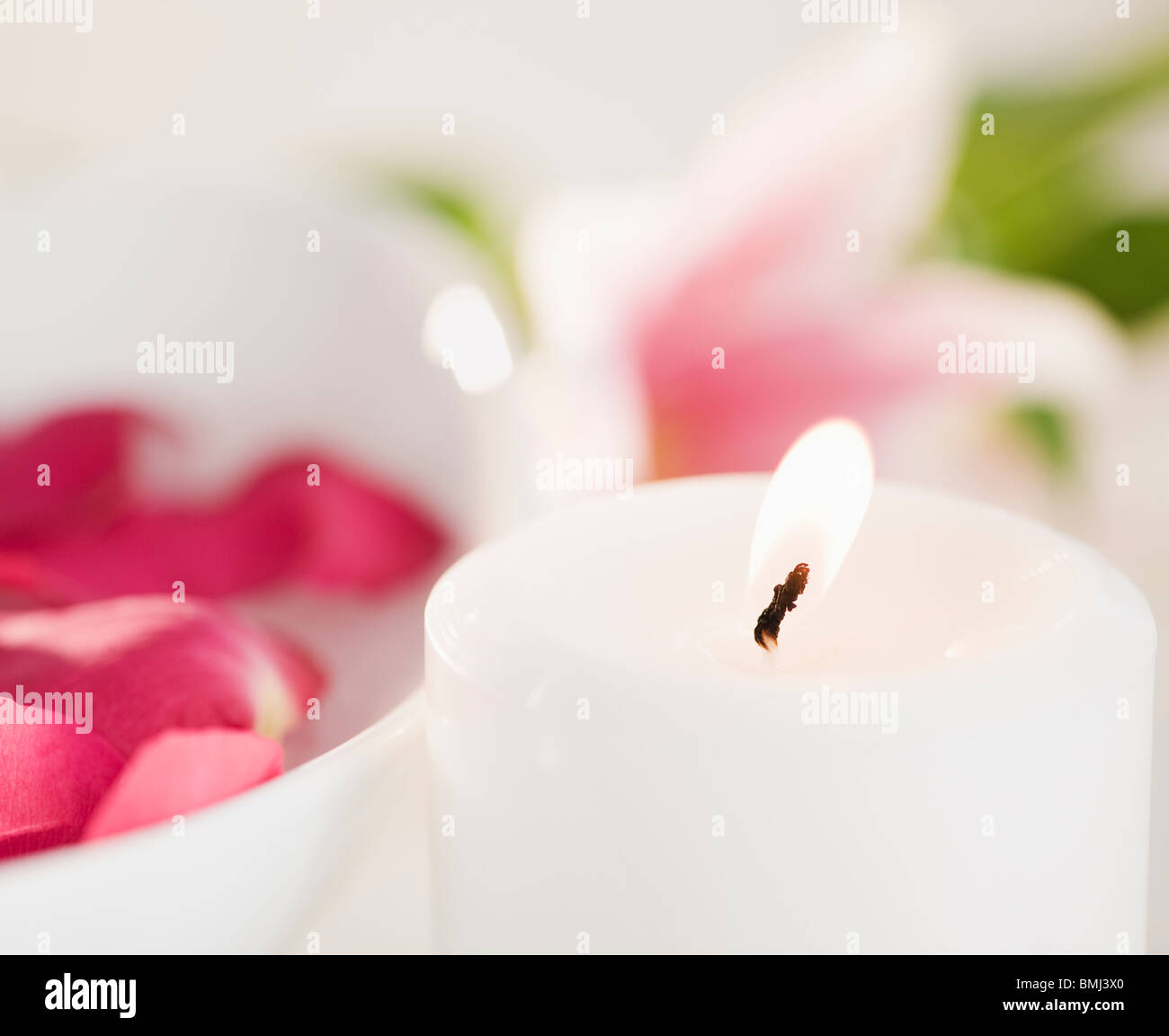Candle and bowl of rose petals Stock Photo - Alamy