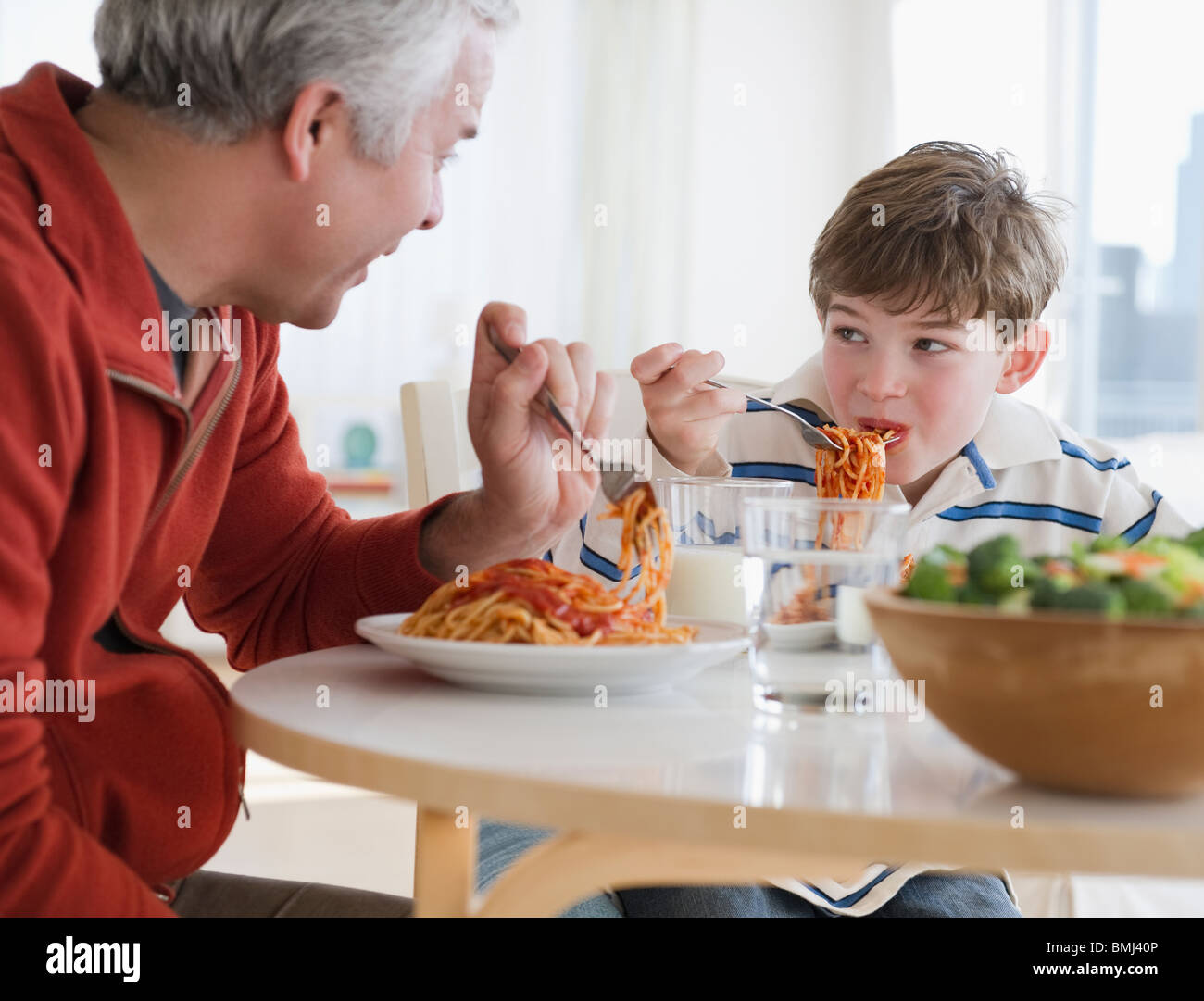 Father and son eating spaghetti Stock Photo