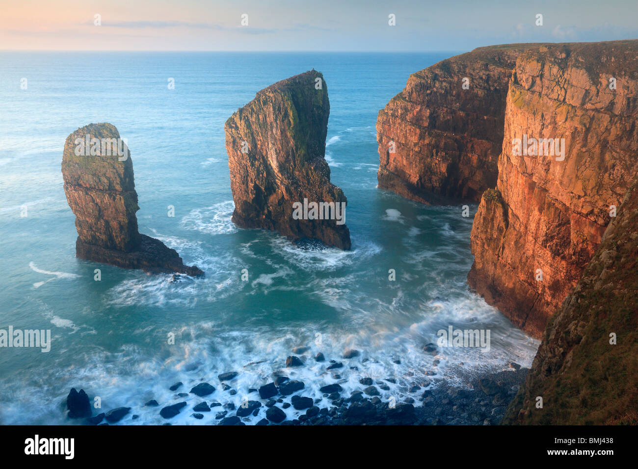 The Elegug Stacks at dawn on a winter's morning along the Pembrokeshire Coast Path in Wales Stock Photo
