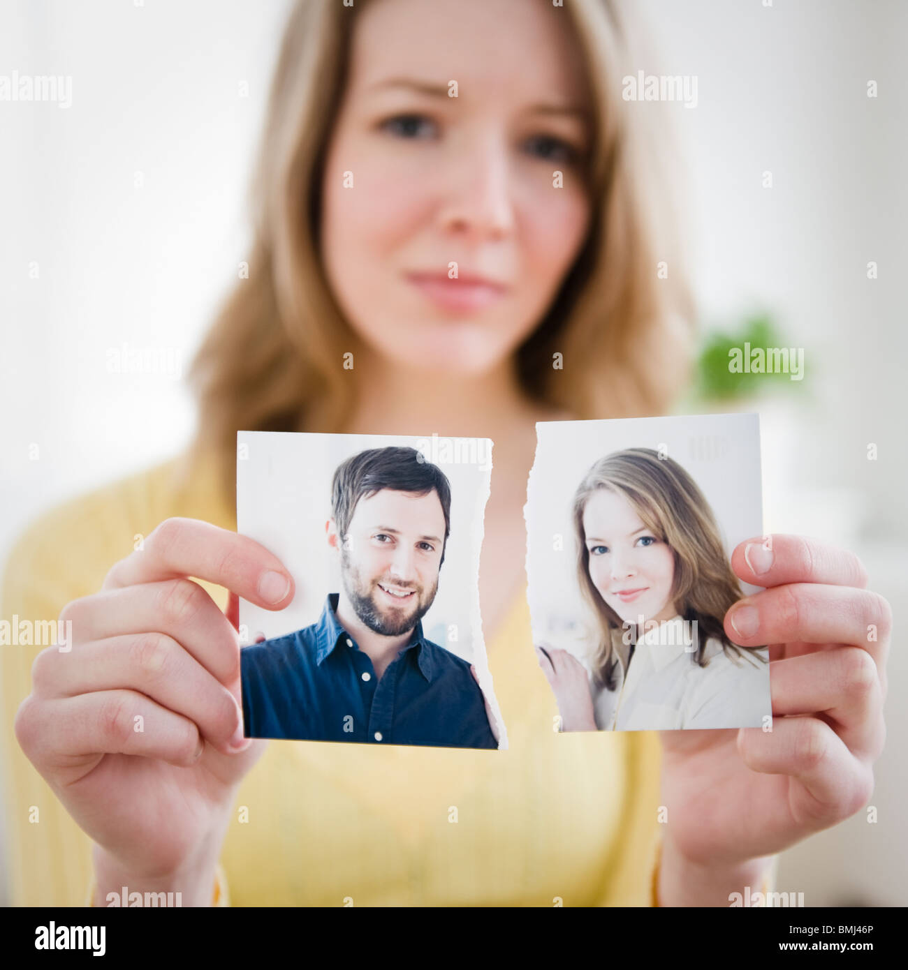 Woman holding torn photograph Stock Photo