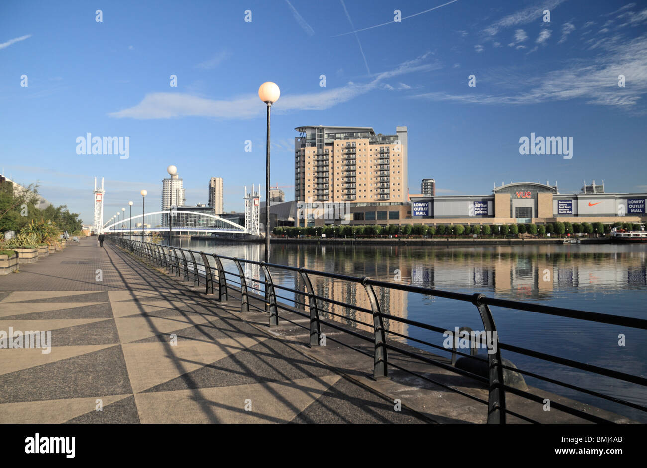 View along the quayside of Salford Quays towards the Millennium footbridge and the Lowry Outlet Mall. Stock Photo