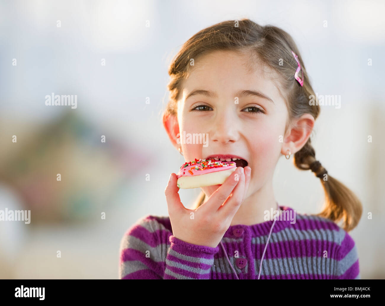 Young girl eating a cookie Stock Photo Alamy