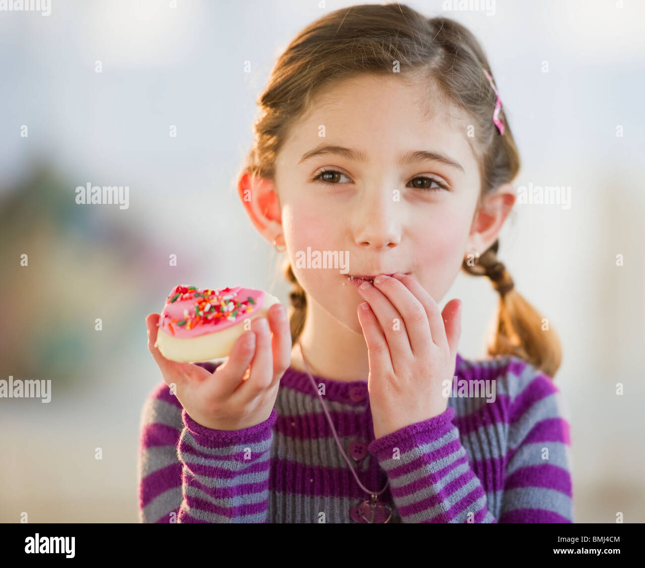 Young girl eating a cookie Stock Photo Alamy