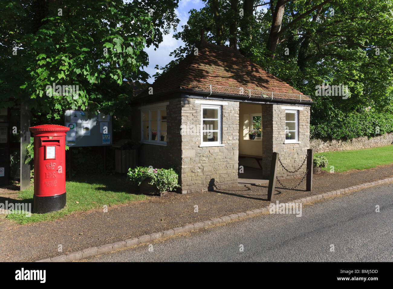 Bus shelter in the village of Weston Underwood, complete with potted plants and Post Box, Buckinghamshire, UK Stock Photo