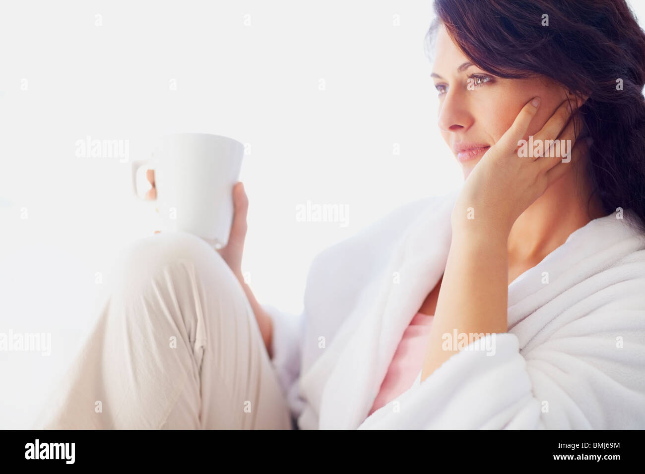 Woman in bathrobe drinking coffee Stock Photo Alamy