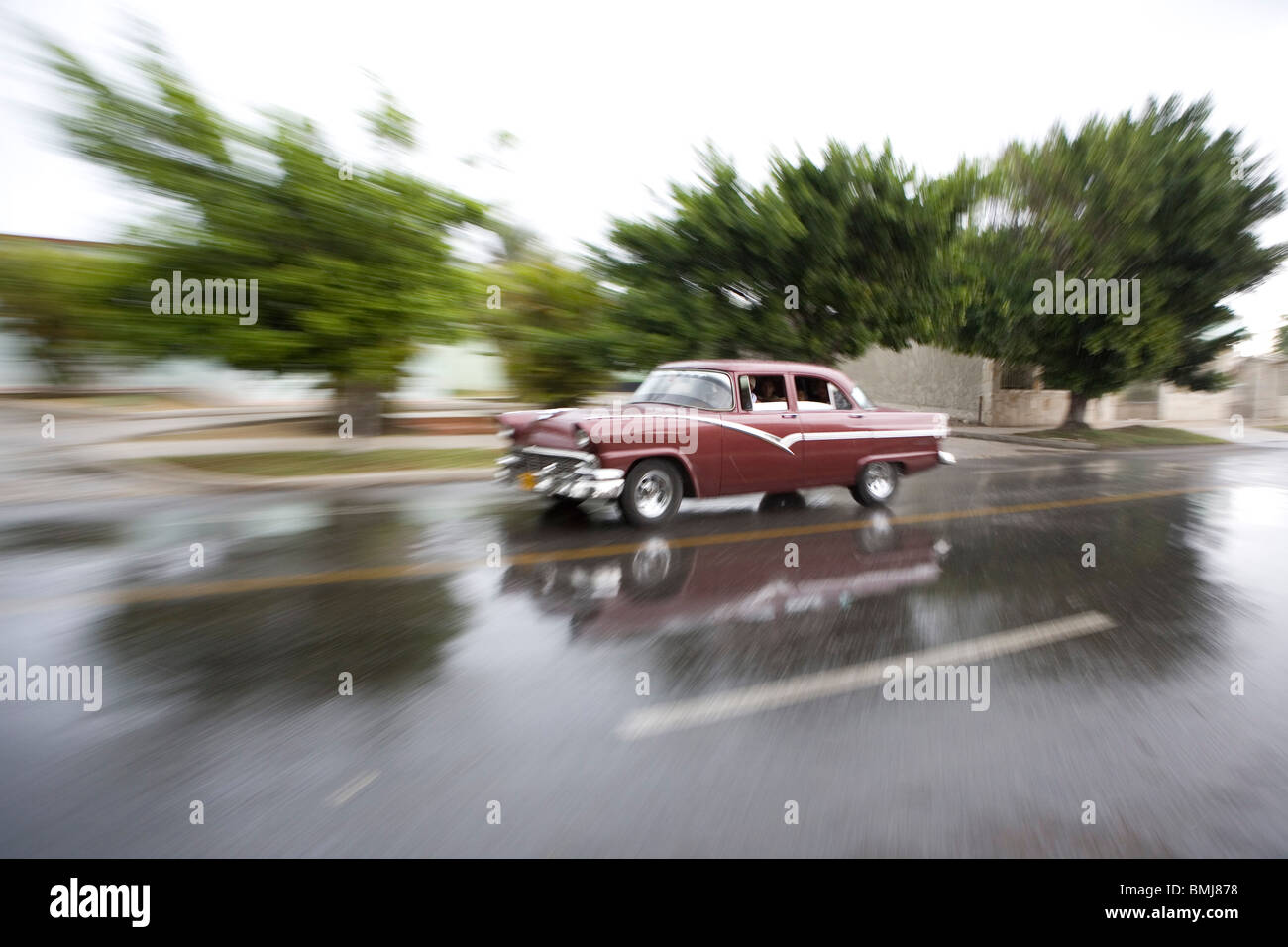 Classic American car during a rain storm in Guanabo along the Playas del Este, Cuba. Stock Photo