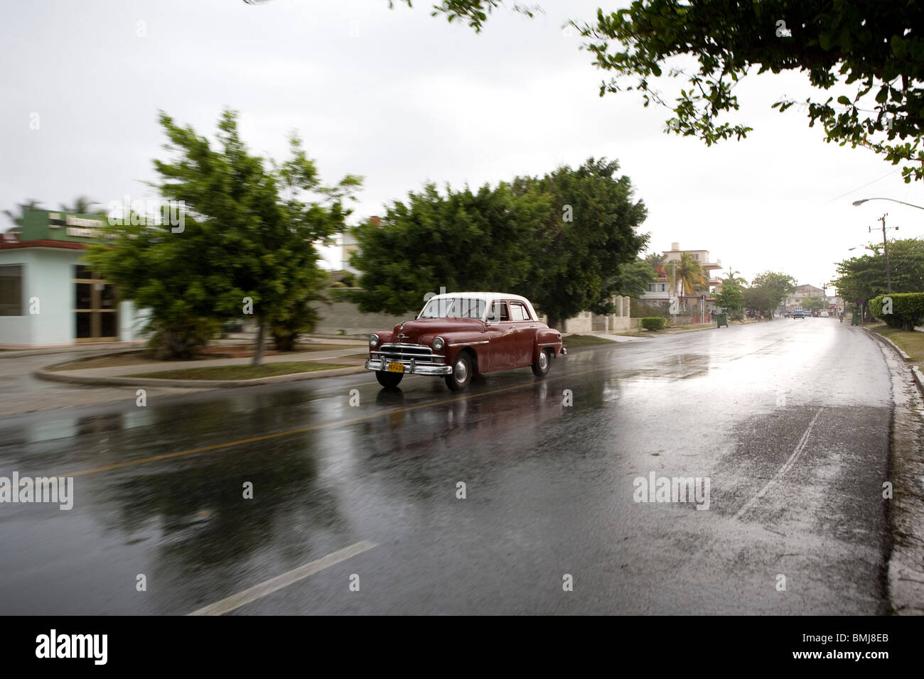 Classic American car during a rain storm in Guanabo along the Playas del Este, Cuba. Stock Photo